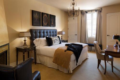 洛斯阿圖斯的住宿－入迷精品酒店，一间卧室配有一张床、一张桌子和一张桌子