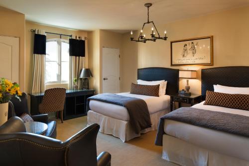 a hotel room with two beds and a chair at Enchante Boutique Hotel in Los Altos