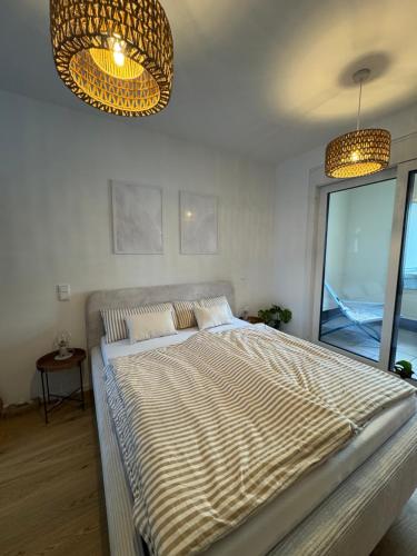 a large bed in a bedroom with two lights at Zentrale Citywohnung Bayreuth, Loggia, Garage in Bayreuth