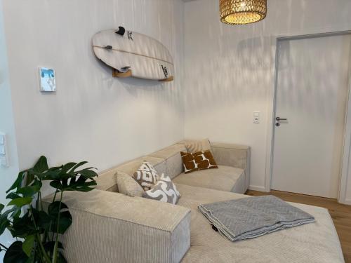 a living room with a couch and a surfboard on the wall at Zentrale Citywohnung Bayreuth, Loggia, Garage in Bayreuth