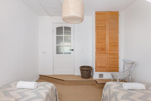 a room with two beds and a chair and a window at Coastal Escape I 2-Bd Stay in Melnragė I ᴄᴏʜᴏsᴛ in Melnragė
