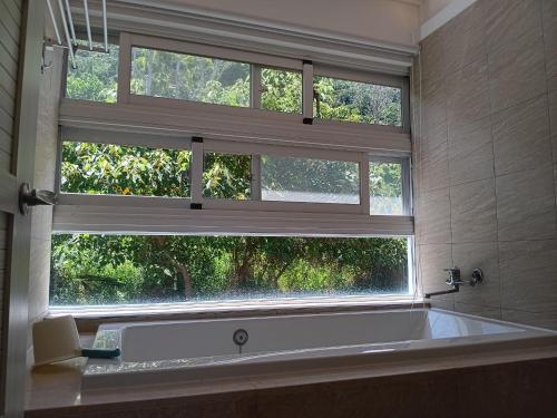 a bath tub in a bathroom with two windows at 高一 33 班 Homestay 1982 in Chenggong