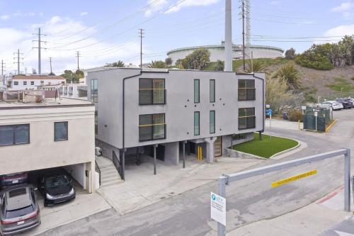 a white building on a street with a parking lot at Tide House - Unit A - Modern Seaside 1BD w Parking in El Segundo