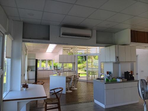 a large kitchen with white cabinets and a dining room at 高一 33 班 Homestay 1982 in Chenggong