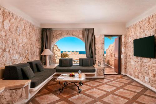 a living room with a couch and a tv at Pickalbatros Citadel Resort Sahl Hasheesh in Hurghada