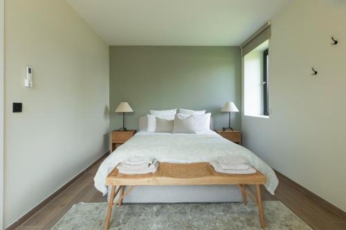 a bedroom with a large bed with white sheets and pillows at La Barzalière in Chimay