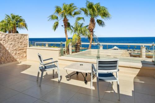 a patio with a table and chairs and the ocean at Pickalbatros Citadel Resort Sahl Hasheesh in Hurghada