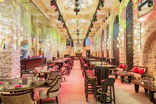 a restaurant with tables and chairs in a building at Pickalbatros Citadel Resort Sahl Hasheesh in Hurghada