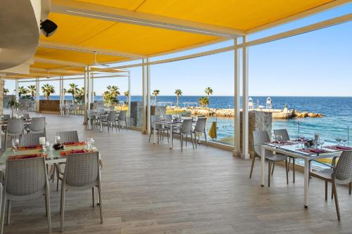 a restaurant with tables and chairs and a view of the ocean at Pickalbatros Citadel Resort Sahl Hasheesh in Hurghada