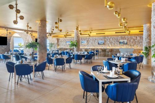 a dining room with tables and blue chairs at Pickalbatros Citadel Resort Sahl Hasheesh in Hurghada