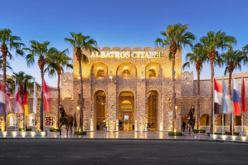 a building with palm trees in front of it at Pickalbatros Citadel Resort Sahl Hasheesh in Hurghada