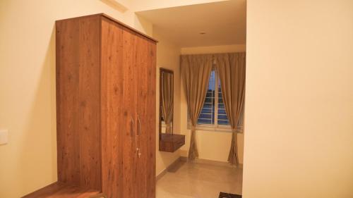 a wooden cabinet in a room with a window at Ganesh Residency 