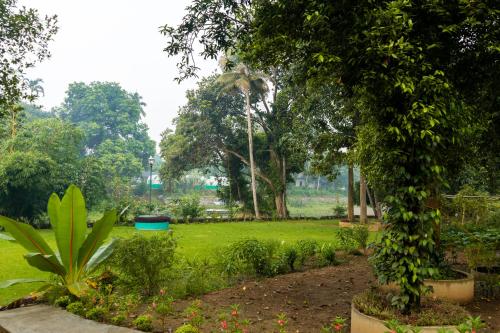 a garden with a green field and trees at Vajra Periyar Heritage in Alwaye