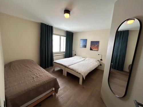 a small bedroom with a bed and a mirror at Casa Partnun 4-3 in Laax-Murschetg