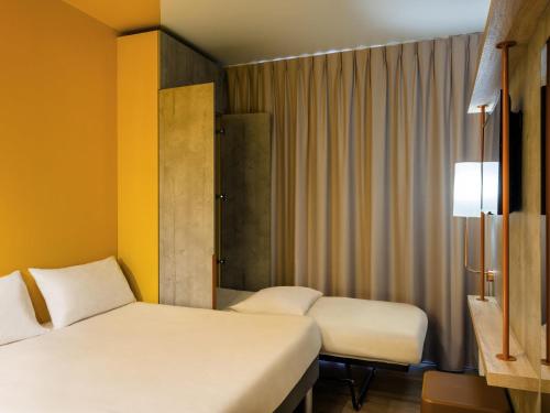 a hotel room with two beds and a window at ibis Budget Mâcon Crêches in Chaintré