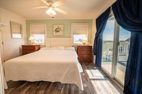 a bedroom with a bed and a large window at Genesis On The Water, Views! Views! Views! in Rodanthe