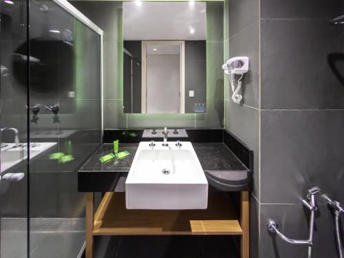 a bathroom with a white sink and a shower at ibis Styles Rio de Janeiro Botafogo in Rio de Janeiro