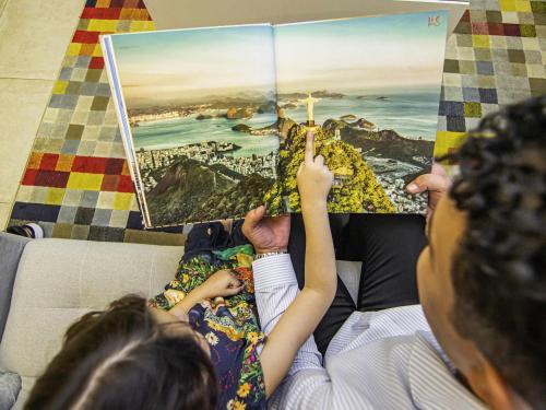 two people laying on a couch reading a book at ibis Styles Rio de Janeiro Botafogo in Rio de Janeiro