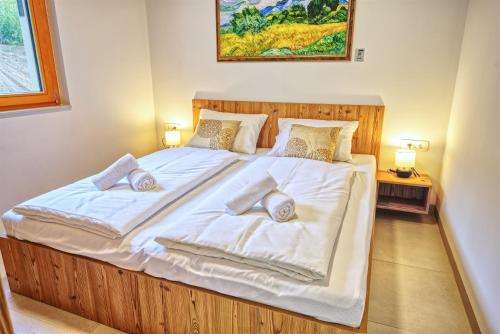 a bedroom with a large bed with white sheets and pillows at House Elipsa in Bovec