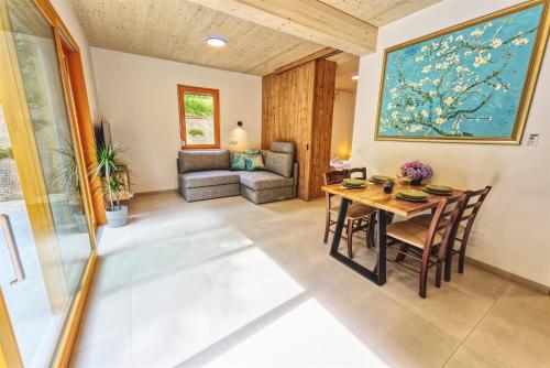 a dining room with a table and a couch at House Elipsa in Bovec