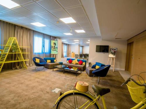 a living room with a bike and a couch at Novotel Mohammedia in Mohammedia