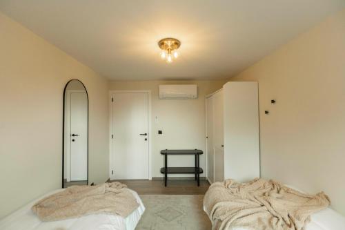 a bedroom with a bed and a table and mirrors at La Barzalière in Chimay