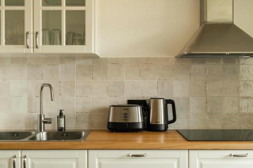 a kitchen counter with a coffee maker and a sink at La Barzalière in Chimay