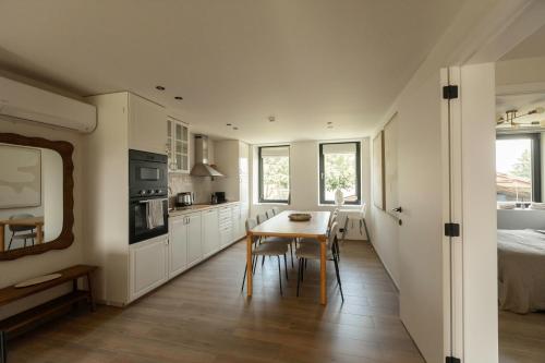 a kitchen with white cabinets and a table with chairs at La Barzalière in Chimay