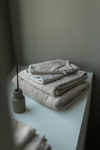 a pile of towels sitting on a counter in a bathroom at La Barzalière in Chimay