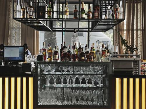 a bar with a lot of bottles and glasses at Novotel Mohammedia in Mohammedia