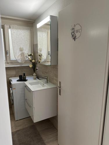 a white bathroom with a sink and a mirror at Gästehaus MaryVitty, zentrale zwischen Aarau und Olten, gut verbunden in Schönenwerd