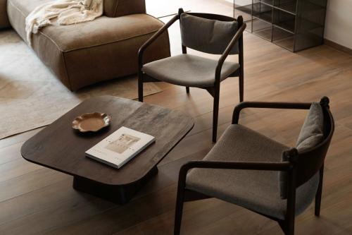 a living room with a coffee table and two chairs at La Barzalière in Chimay