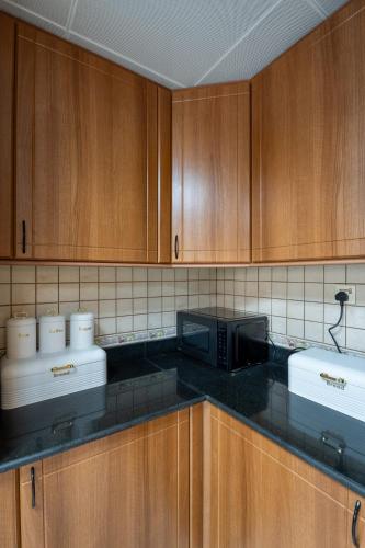 a kitchen with wooden cabinets and a microwave at Veer Apartments - 87th Floor Penthouse Full Sea View 5 BHK in Dubai