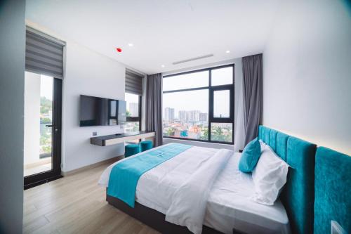 Un dormitorio con una cama grande y una ventana grande. en MAREMONTI Luxury 5 Star Hotel, en Ha Long