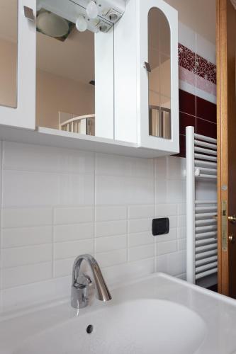 a white kitchen with a sink and a mirror at Principe di Piemonte Apartment in Campobasso