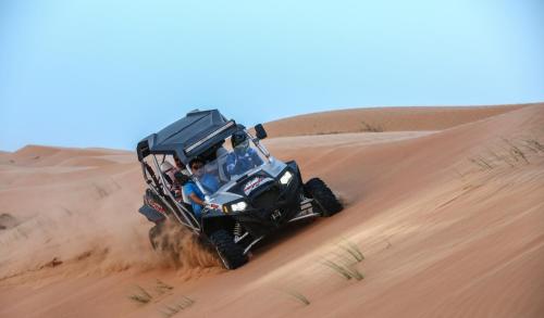 a atv driving through the sand in the desert at Modern Desert Gate Resort Bidiyah in Al Raka