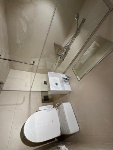 a white bathroom with a toilet and a sink at Trip made in Busan