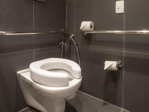 a bathroom with a white toilet in a stall at ibis Styles Rondonopolis in Rondonópolis