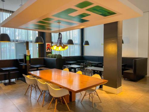 a dining room with a wooden table and chairs at ibis Styles Rondonopolis in Rondonópolis