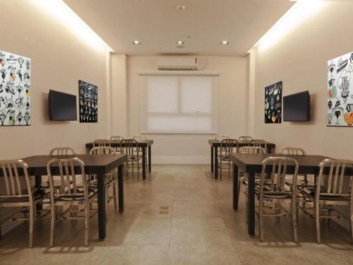 a room with tables and chairs and a window at ibis Styles Rondonopolis in Rondonópolis