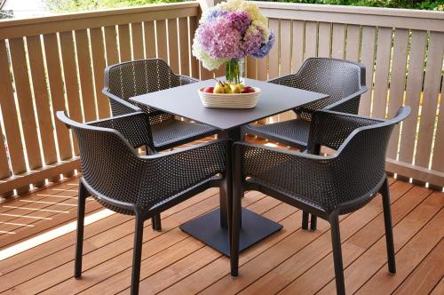 a table with chairs and a vase of flowers on a deck at House Elipsa in Bovec