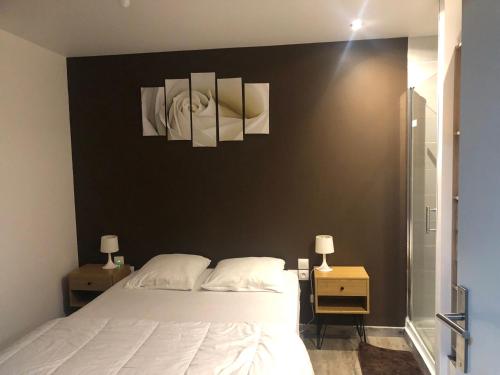 a bedroom with a white bed and two nightstands and two lamps at Villa Blanche appartement 2 in Le Mont-Dore