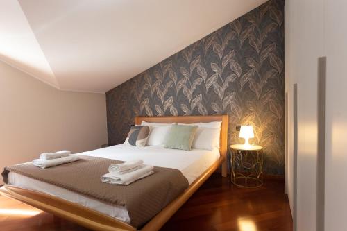 カンポバッソにあるPrincipe di Piemonte Apartmentのベッドとタオル2枚のある寝室