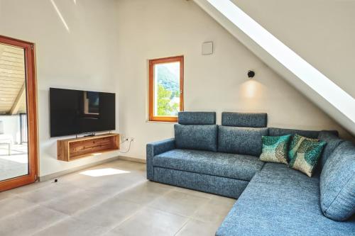 a living room with a couch and a tv at House Elipsa in Bovec