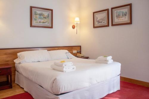 a hotel room with a bed with towels on it at Hostal Navarra in Pamplona