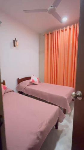 a hospital room with two beds and an orange curtain at SAN Holiday in Wadduwa