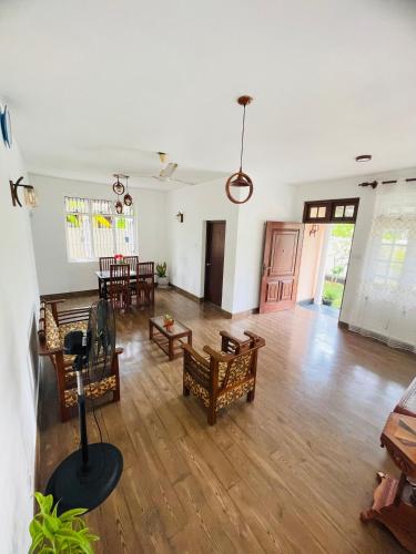 an empty living room with wooden floors and chairs at SAN Holiday in Wadduwa