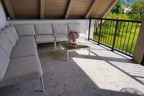 a screened in porch with a couch and a table at House Elipsa in Bovec