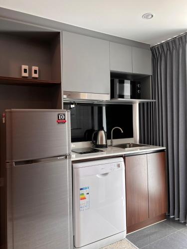a kitchen with a refrigerator and a sink at 12 The Residence Hotel at Don Mueang Airport in Bangkok
