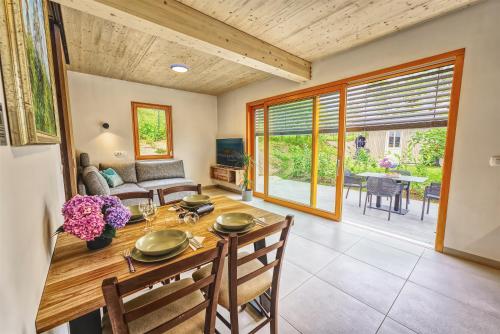 a dining room with a table and a couch at House Elipsa in Bovec
